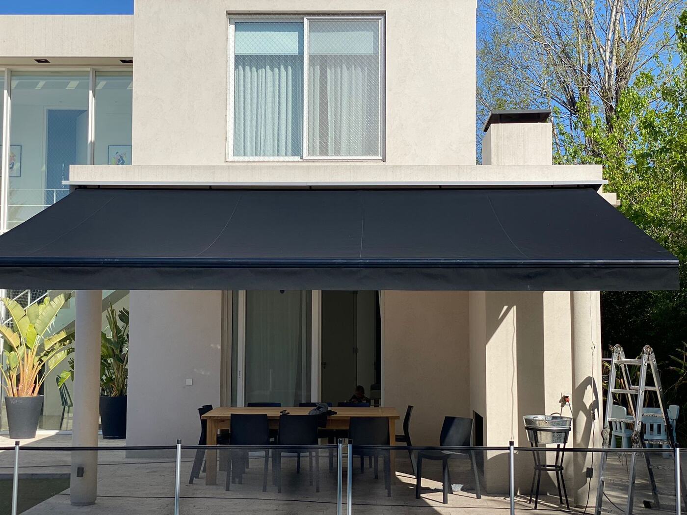 Toldo retráctil gris sobre el patio de una vivienda