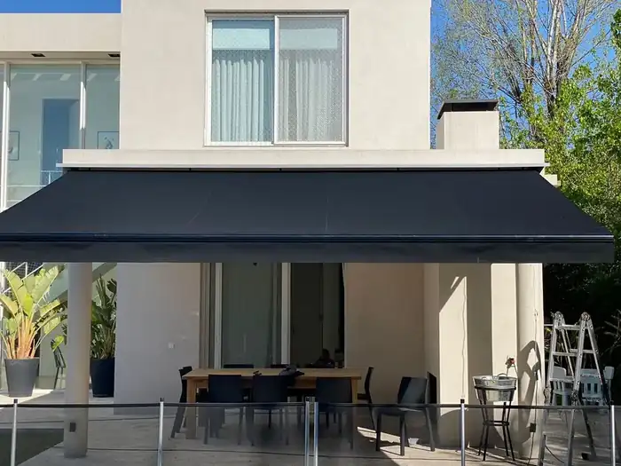 Toldo retráctil gris sobre el patio de una vivienda